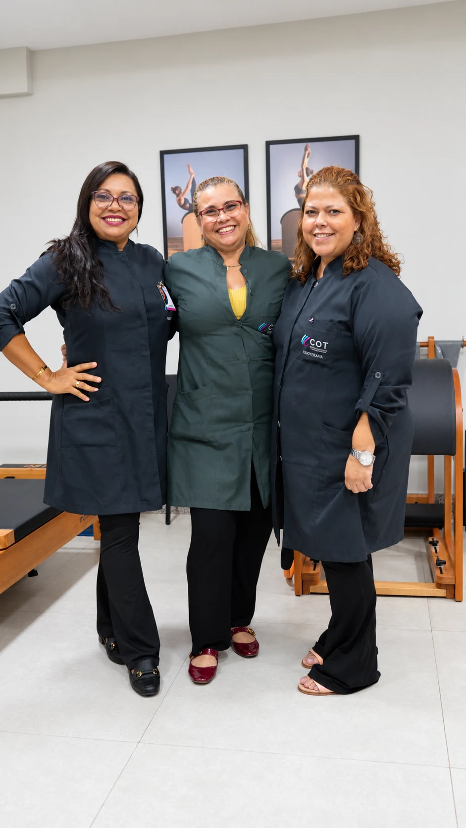 Três fisioterapeutas da equipe do COT, sorrindo, no espaço de Pilates